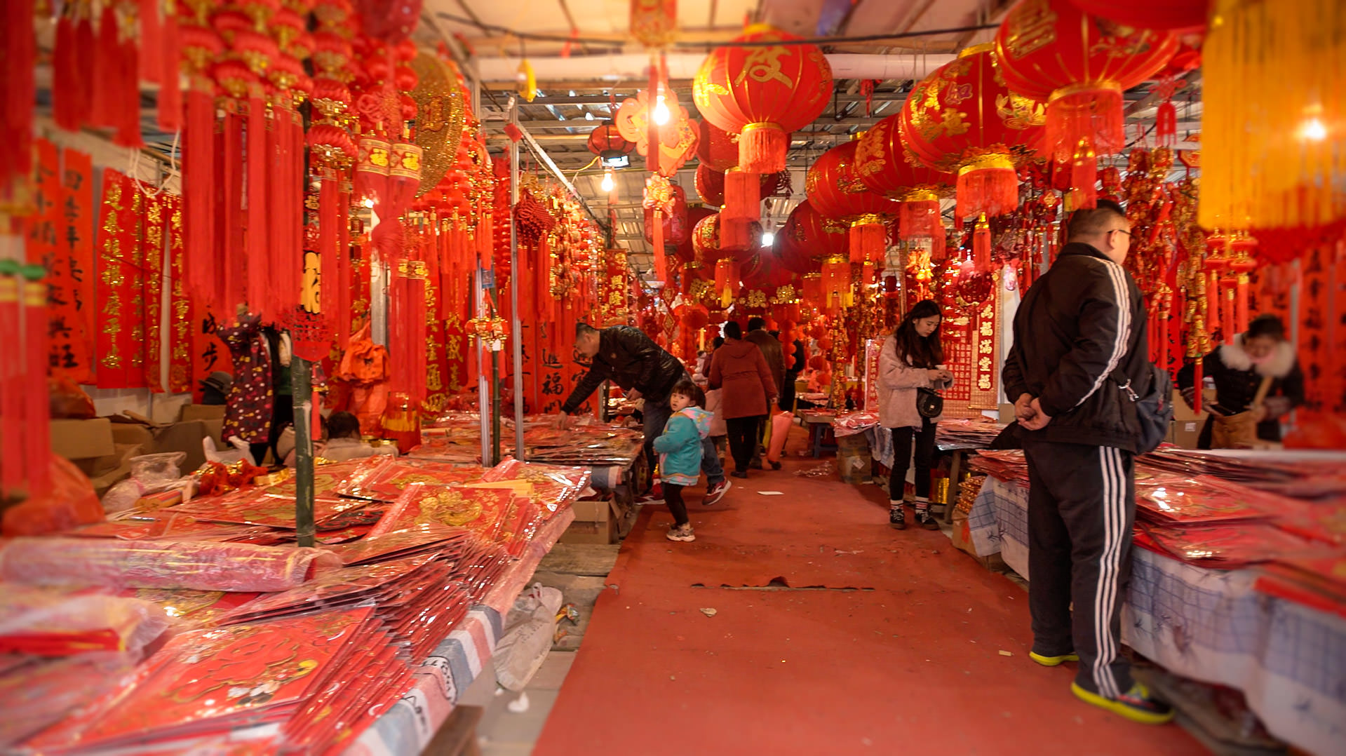 Red Chinese New Year decorations plaster every wall of this underground market
