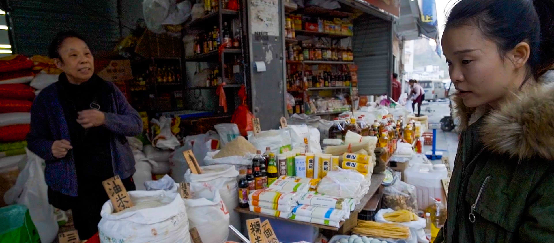 A customer and stall ownder negotiate outside a small market stall