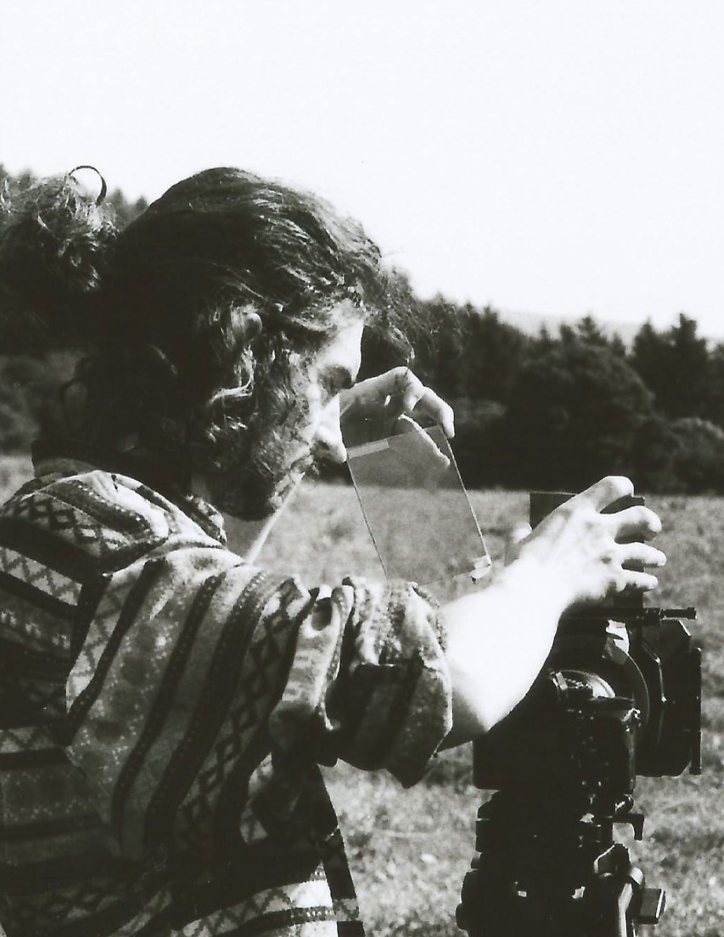 Scott loads a glass filter into a camera, black and white